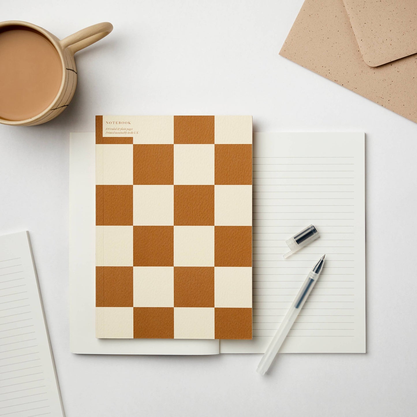 Ochre and cream checkerboard A5 notebook with lined and plain interior pages, styled with coffee and pen – perfect for journaling or creative note-taking.