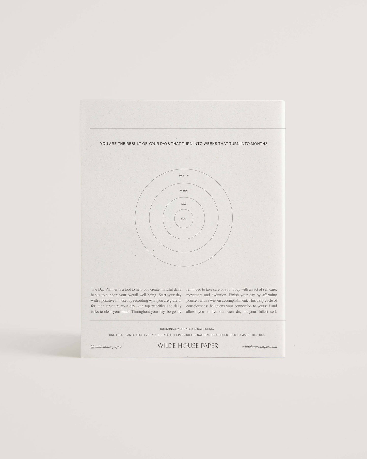 Minimalist white undated daily planner with circular design and wellness prompts on the cover – ideal for tracking gratitude, self-care and daily priorities.