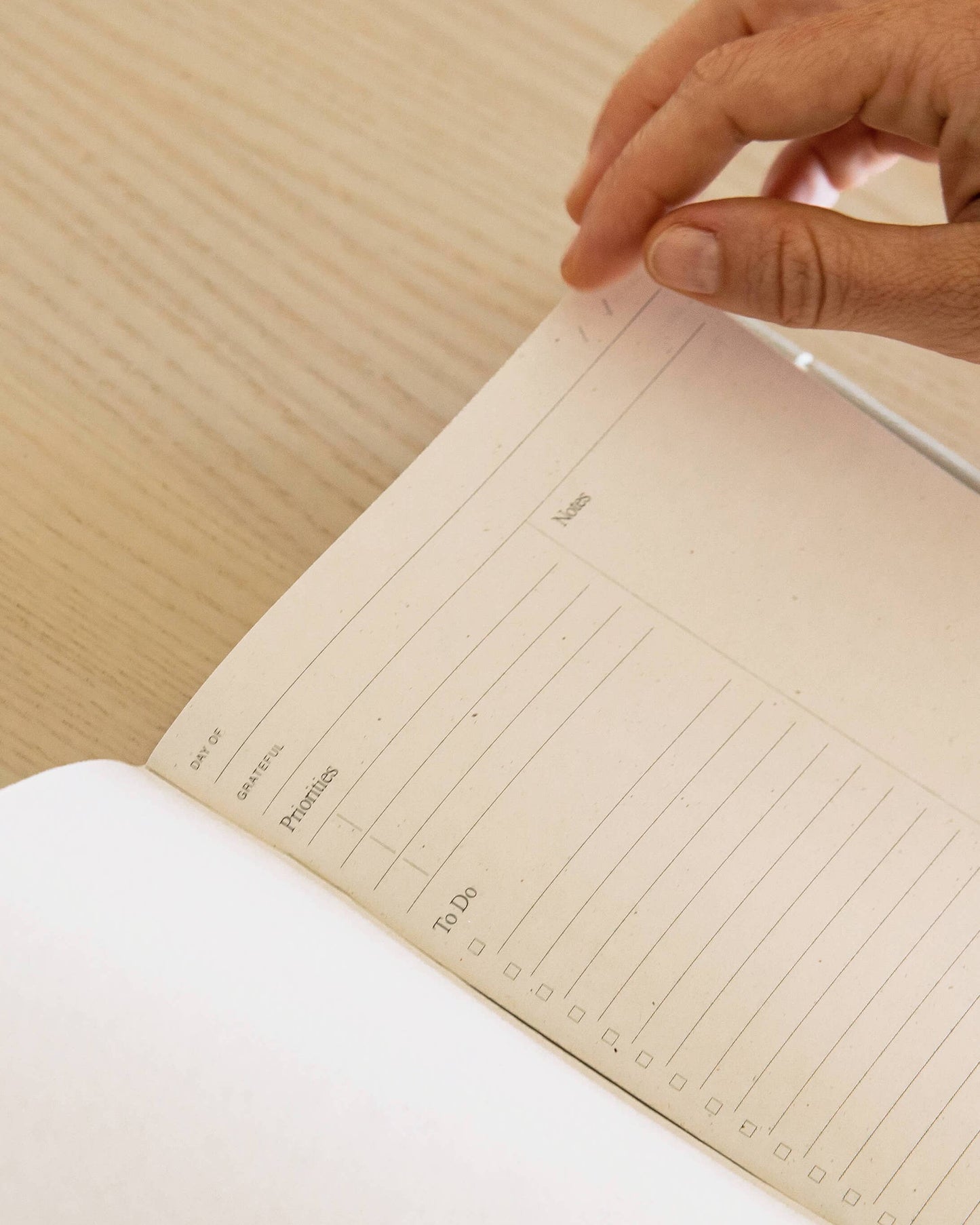 Minimalist white undated daily planner with circular design and wellness prompts on the cover – ideal for tracking gratitude, self-care and daily priorities.