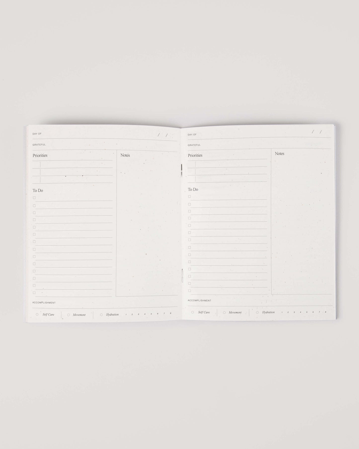 Minimalist white undated daily planner with circular design and wellness prompts on the cover – ideal for tracking gratitude, self-care and daily priorities.