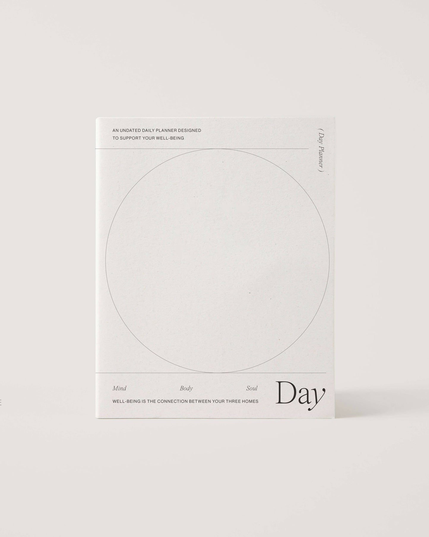 Minimalist white undated daily planner with circular design and wellness prompts on the cover – ideal for tracking gratitude, self-care and daily priorities.