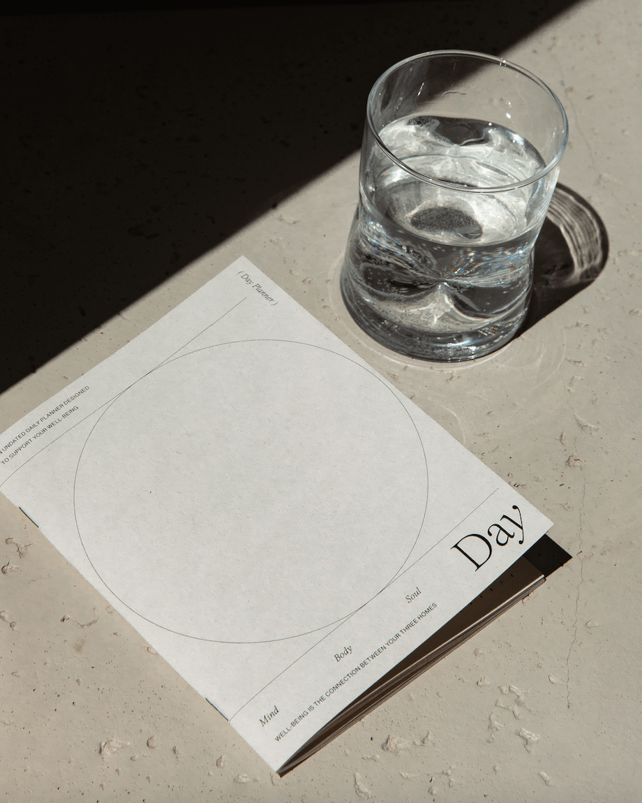 Minimalist white undated daily planner with circular design and wellness prompts on the cover – ideal for tracking gratitude, self-care and daily priorities.