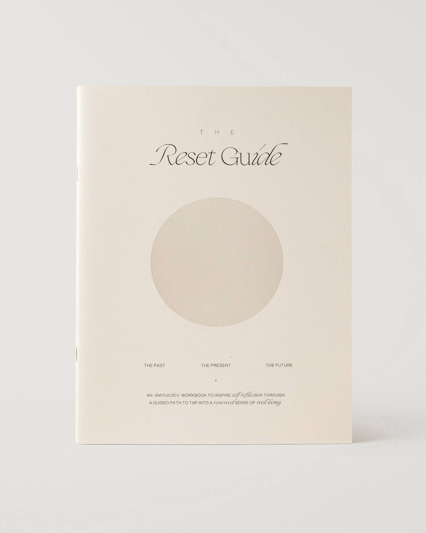 Minimalist beige guided journal titled "The Reset Guide" with soft circular design, created for personal growth and self-reflection through past, present, and future prompts.