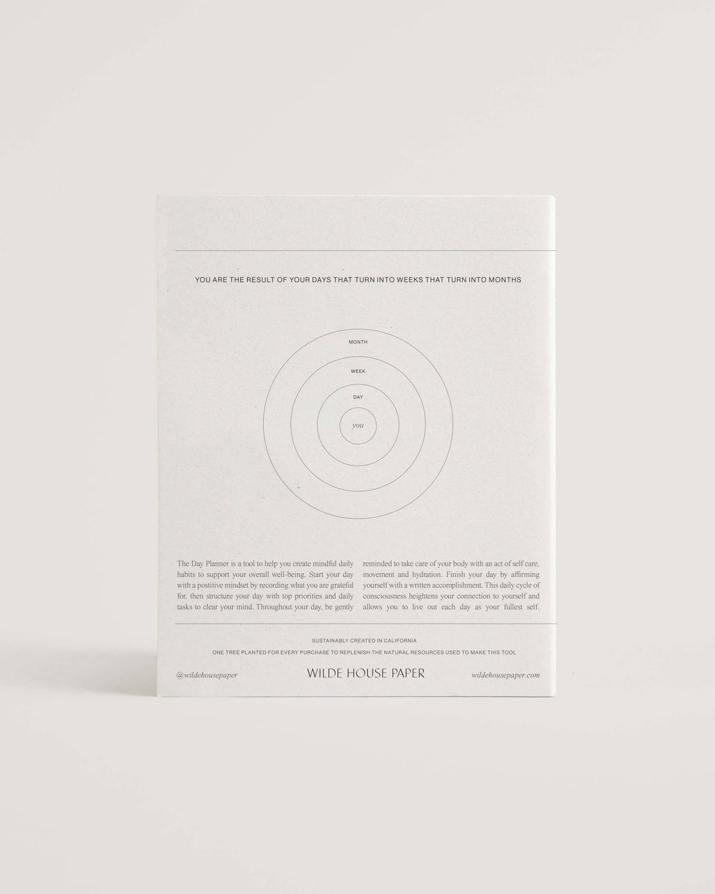 Minimalist white undated daily planner with circular design and wellness prompts on the cover – ideal for tracking gratitude, self-care and daily priorities.