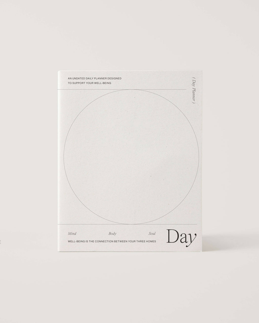 Minimalist white undated daily planner with circular design and wellness prompts on the cover – ideal for tracking gratitude, self-care and daily priorities.