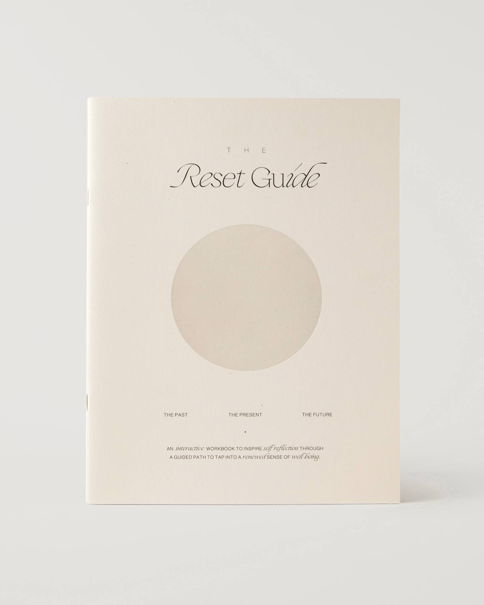 Minimalist beige guided journal titled "The Reset Guide" with soft circular design, created for personal growth and self-reflection through past, present, and future prompts.